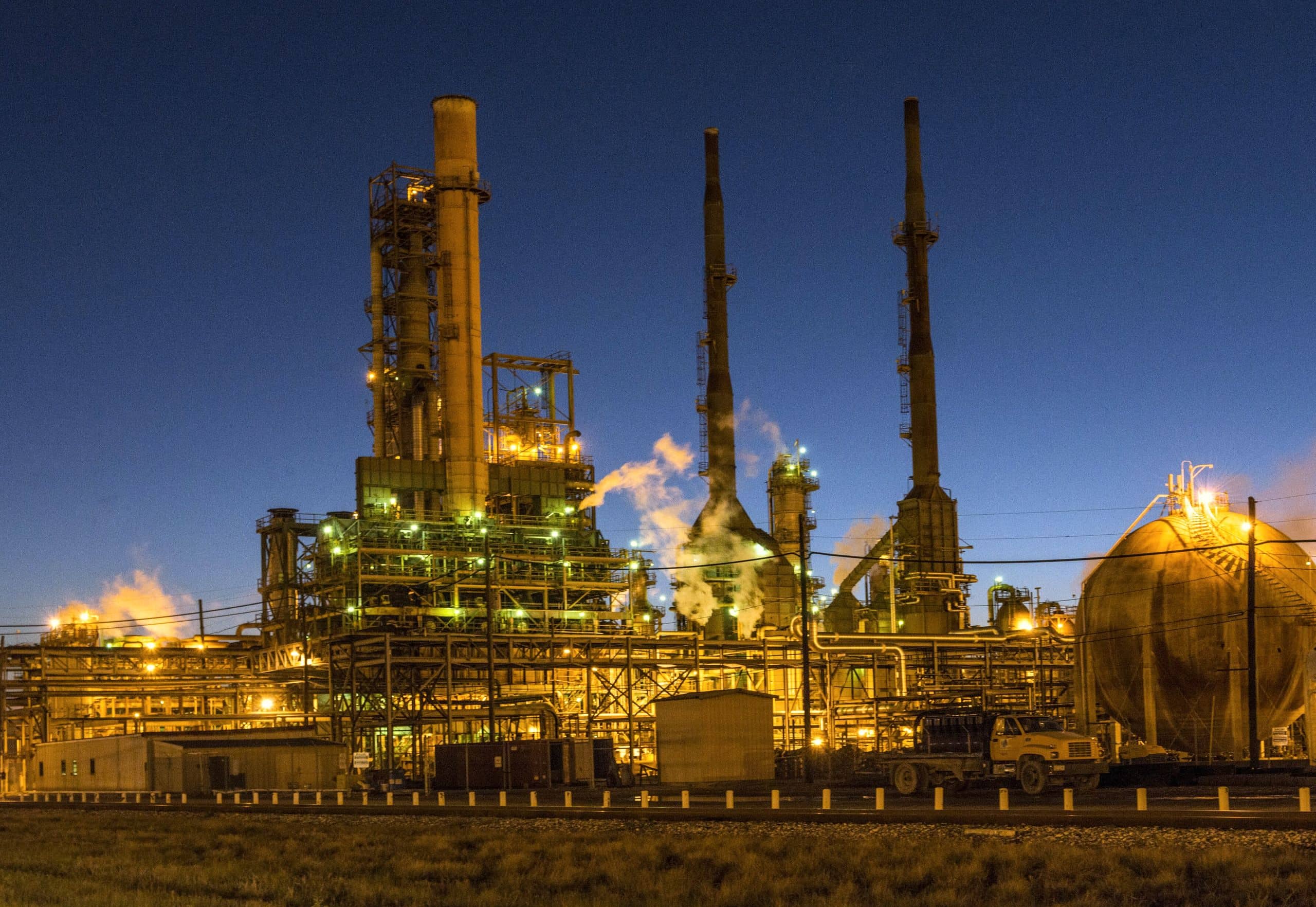 Illuminated industrial fuel processing units at dusk